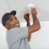 electrician removing battery from smoke detector